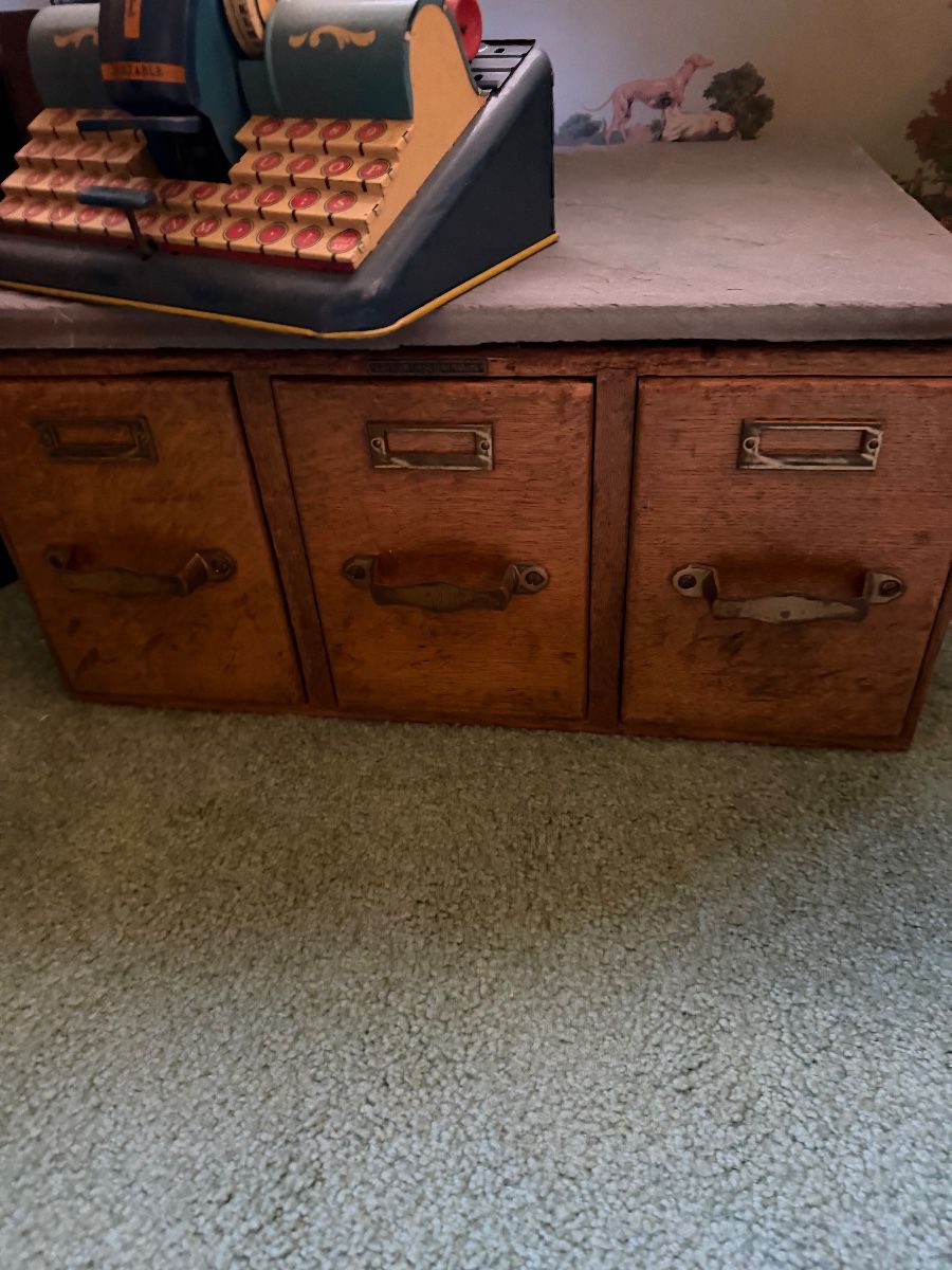 Vintage register displayed on a wooden drawer cabinet at the Caldwell estate sale
